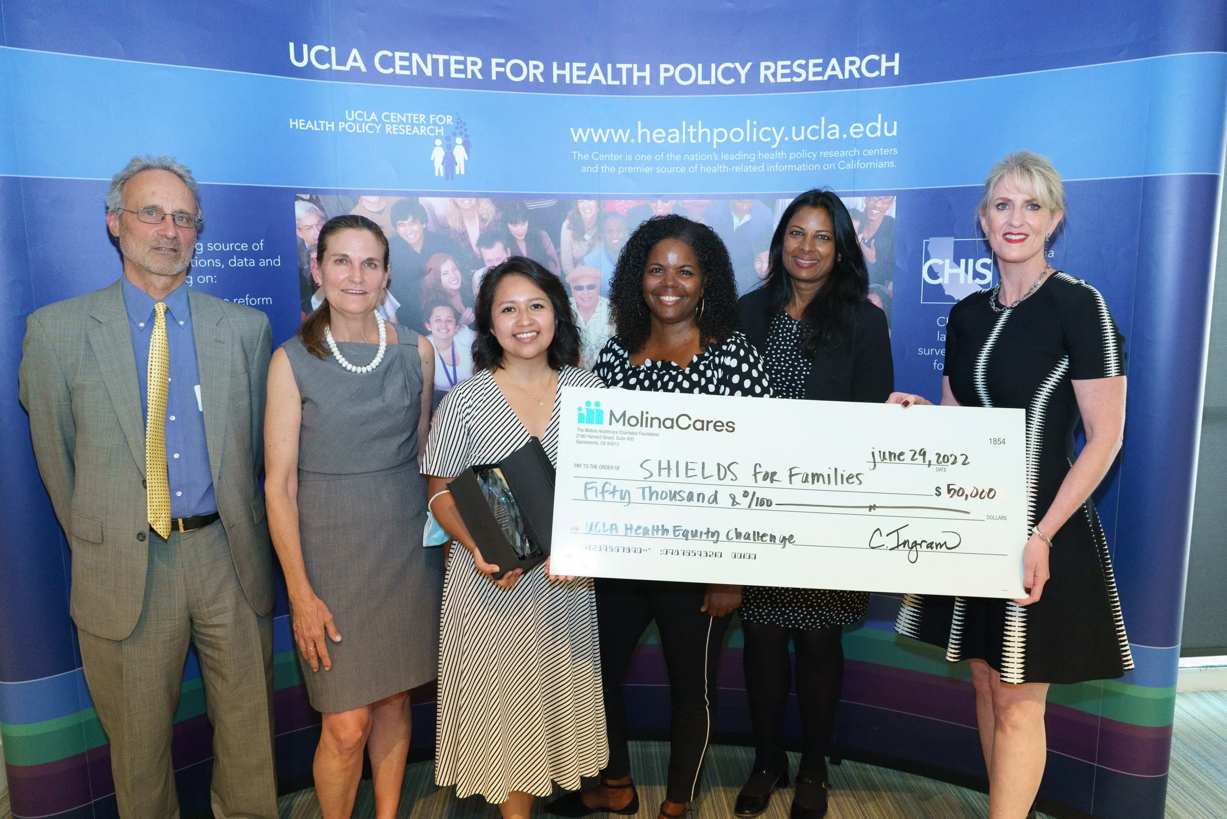 Alma Lopez (center left) with check for 50K to Shields for Families