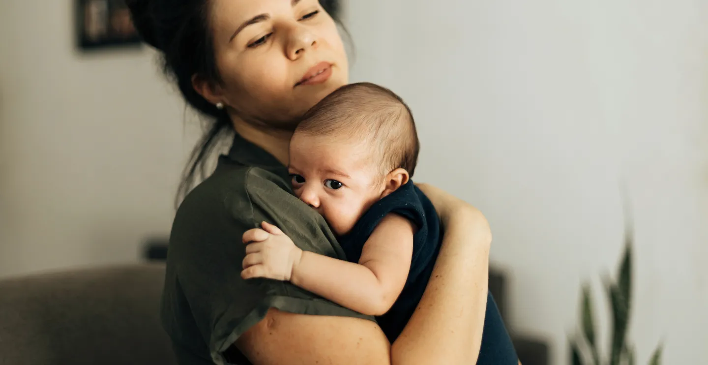 Latinx mother holds her newborn