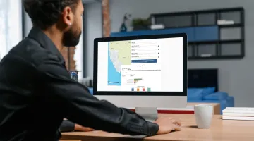 Man looking at a computer monitor with a map of California on the screen along with a graph.