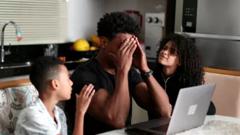 father struggling with two children by his side