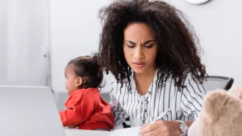 Young mom with toddler in front of laptop