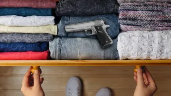 handgun atop jeans in a dresser drawer