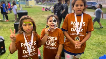 Tres niños con camisetas de Parks After Dark