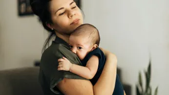 Latinx mother holds her newborn